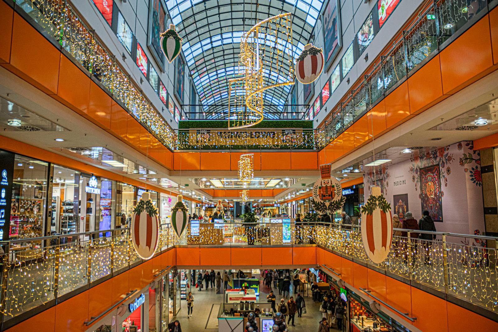 A perspective view inside a shopping mall decorated for Christmas.